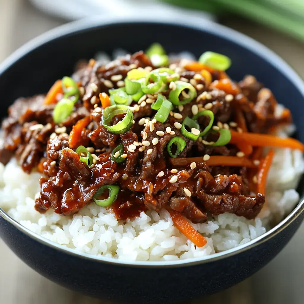 Close-up of a Korean Beef Bowl with rice, beef, vegetables, and garnishes.