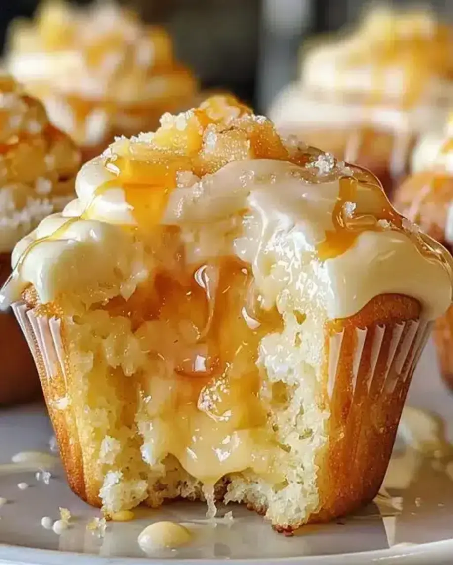 Close-up of a peach cream cheese cupcake with frosting swirls