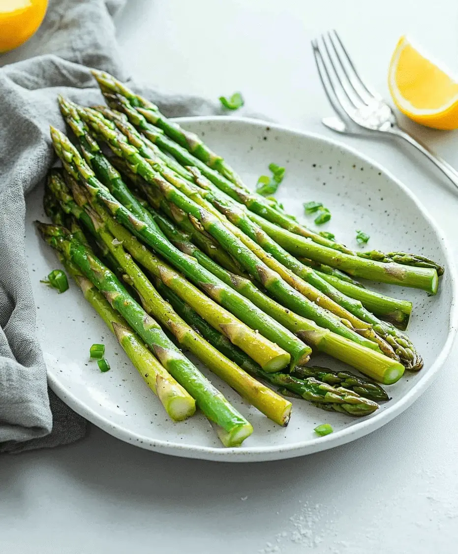 Steamed asparagus on a white plate, seasoned with salt, pepper, and a squeeze of lemon.