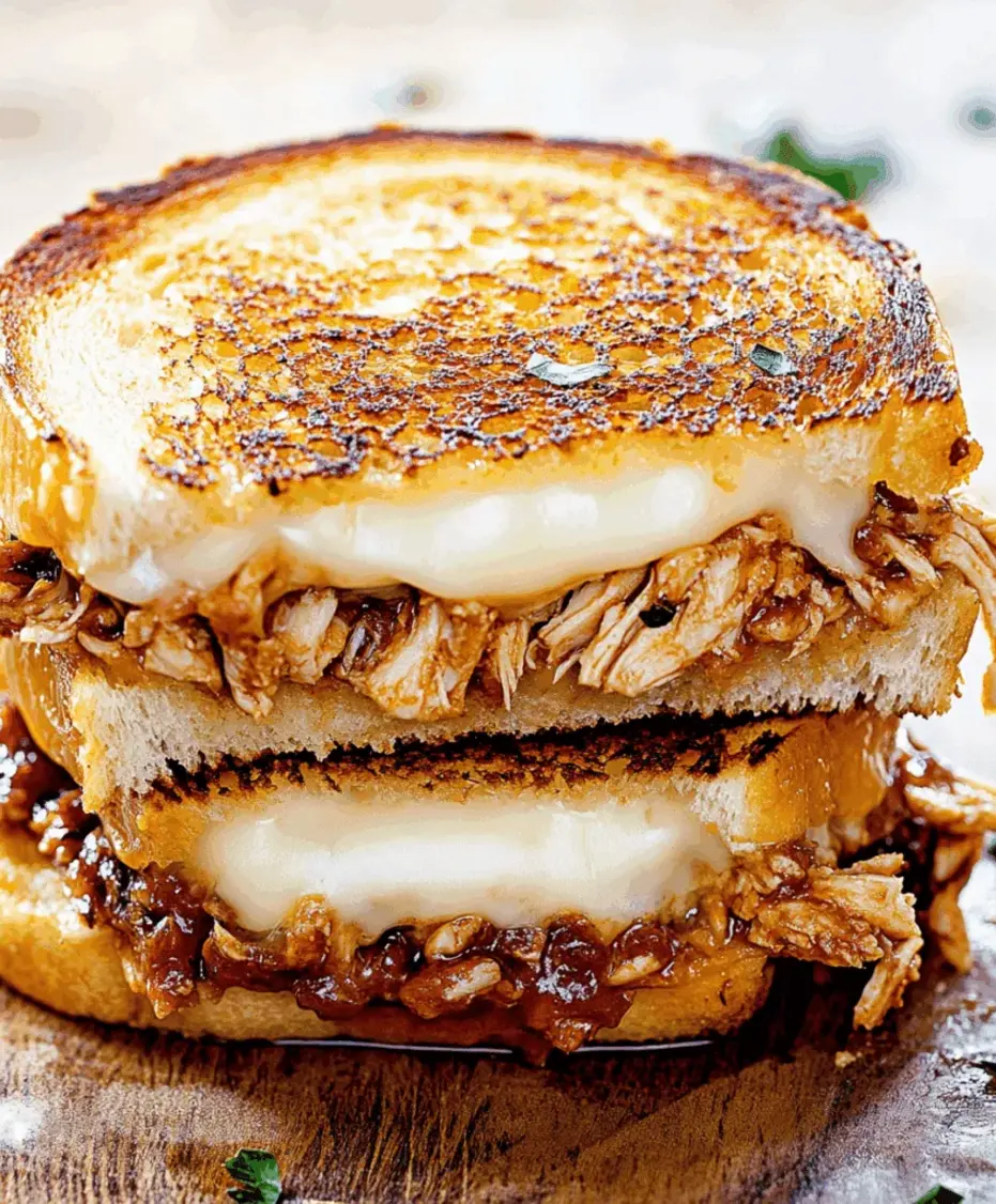 A beautifully plated BBQ Chicken Grilled Cheese sandwich on a wooden board with a side salad and pickles